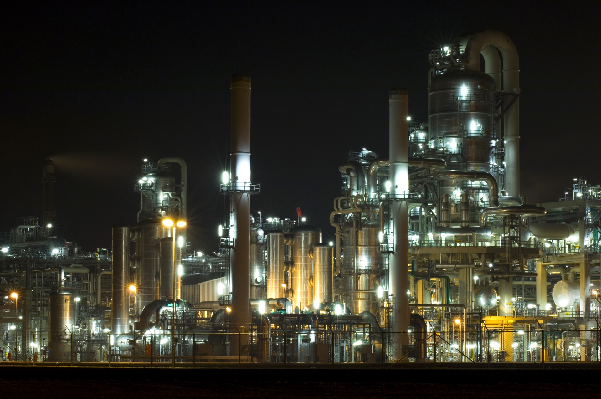 The converters, pipes, tubes chimneys and structures of a illuminated petrochemical plant at night